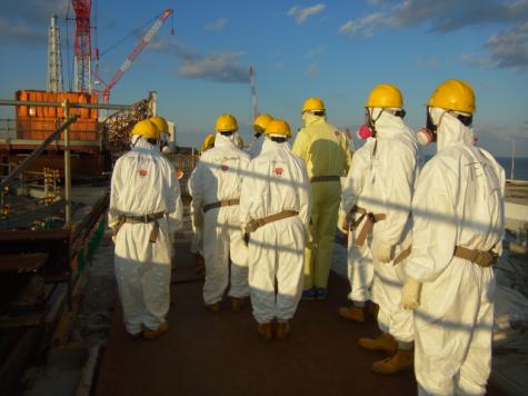 Eine Gruppe Wissenschaftler in Schutzanzügen auf dem Gelände von Fukushima